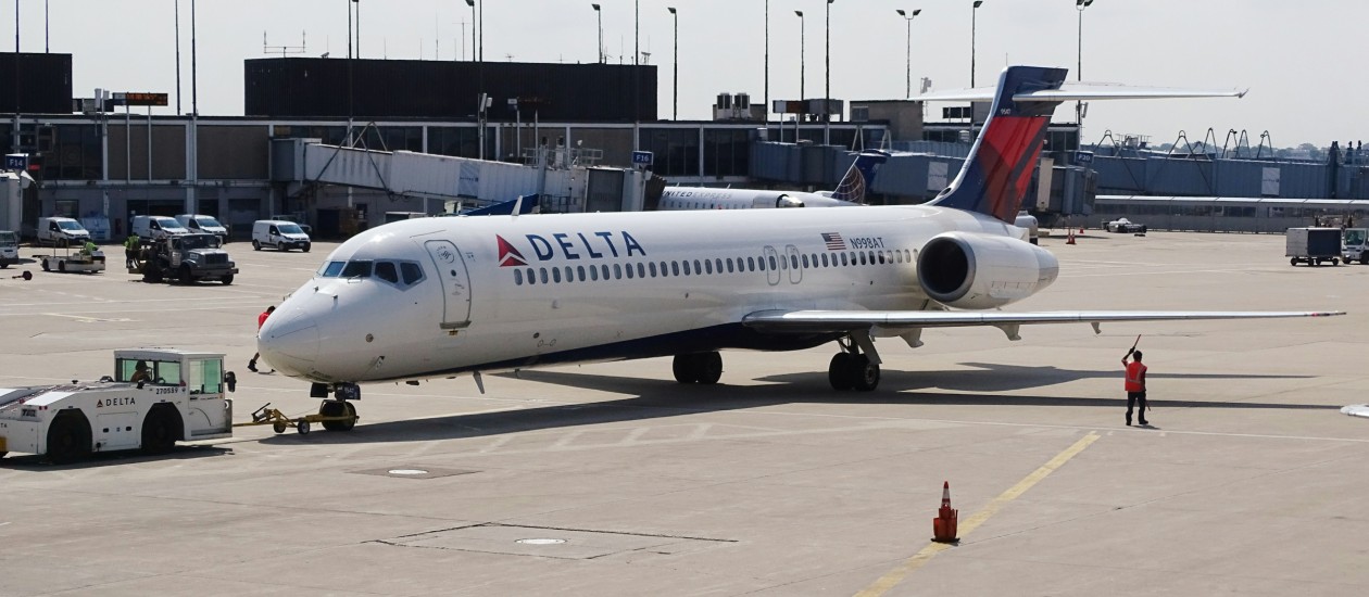 Man standing beside the white delta airplane