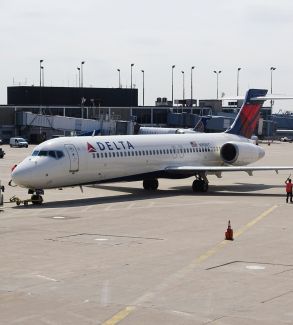 Man standing beside the white delta airplane