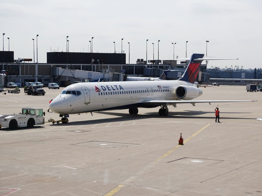 Man standing beside the white delta airplane